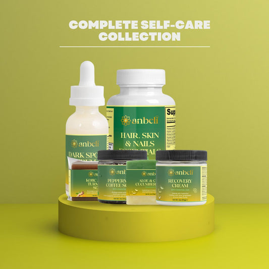 A collection of Anbel branded hair and nail care products, including a bottle of Dark Spot Remover, a bottle of Hair & Nails Vitamin Supplement, a bottle of Hair & Nails Detangling Spray, and a bottle of Hair & Nails Nail Cream, all displayed against a yellow background with the text 'Complete Self-Care Collection'.